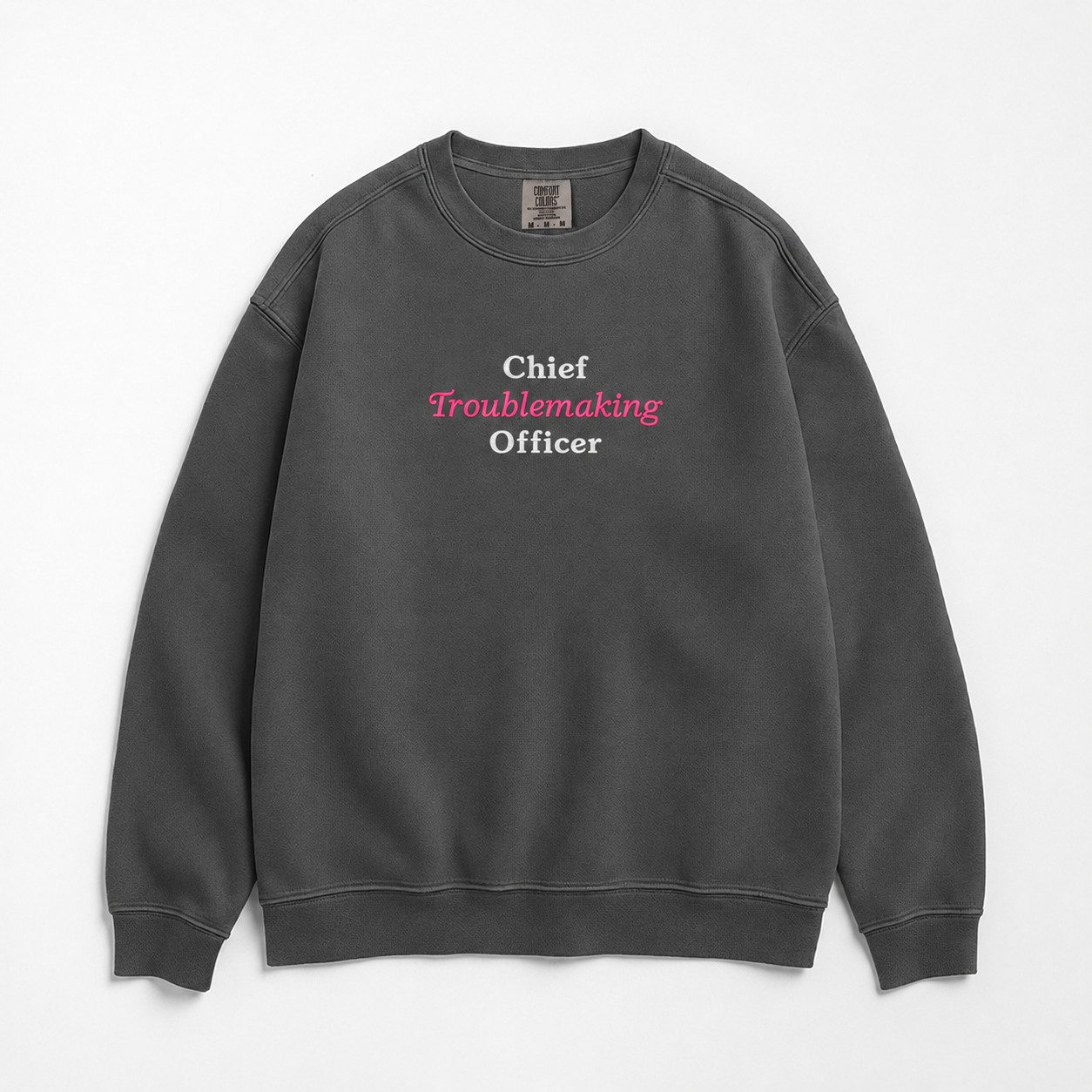 A dark gray crewneck sweatshirt with the text 'Chief Troublemaking Officer' printed on the chest in white and pink lettering, displayed flat against a light gray background.