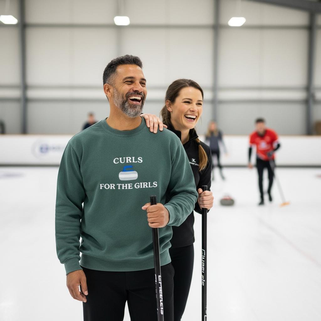 Two people on an indoor ice rink, one wearing a sweatshirt with 'Curls for the Girls' embroidered.