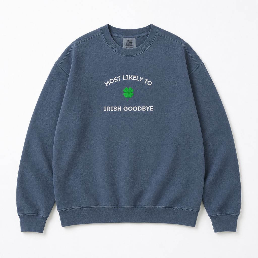 A faded blue crewneck sweatshirt embroidered with white text reading 'MOST LIKELY TO IRISH GOODBYE' and a green four-leaf clover graphic on the chest, displayed flat against a light off-white background.