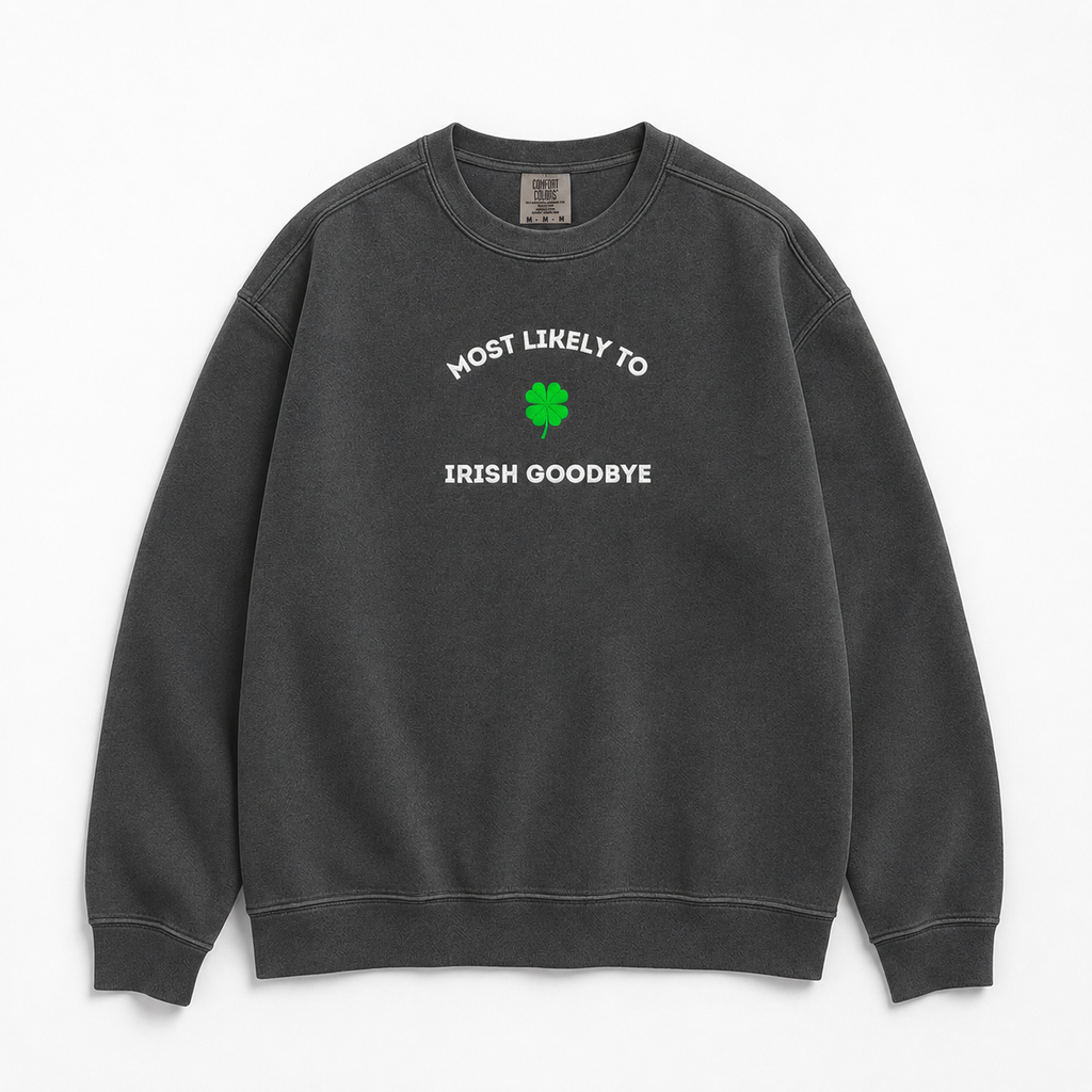 A dark gray crewneck sweatshirt with a graphic on the chest that is embroidered 'MOST LIKELY TO IRISH GOODBYE' in white text around a green four-leaf clover, displayed on a clean white background.