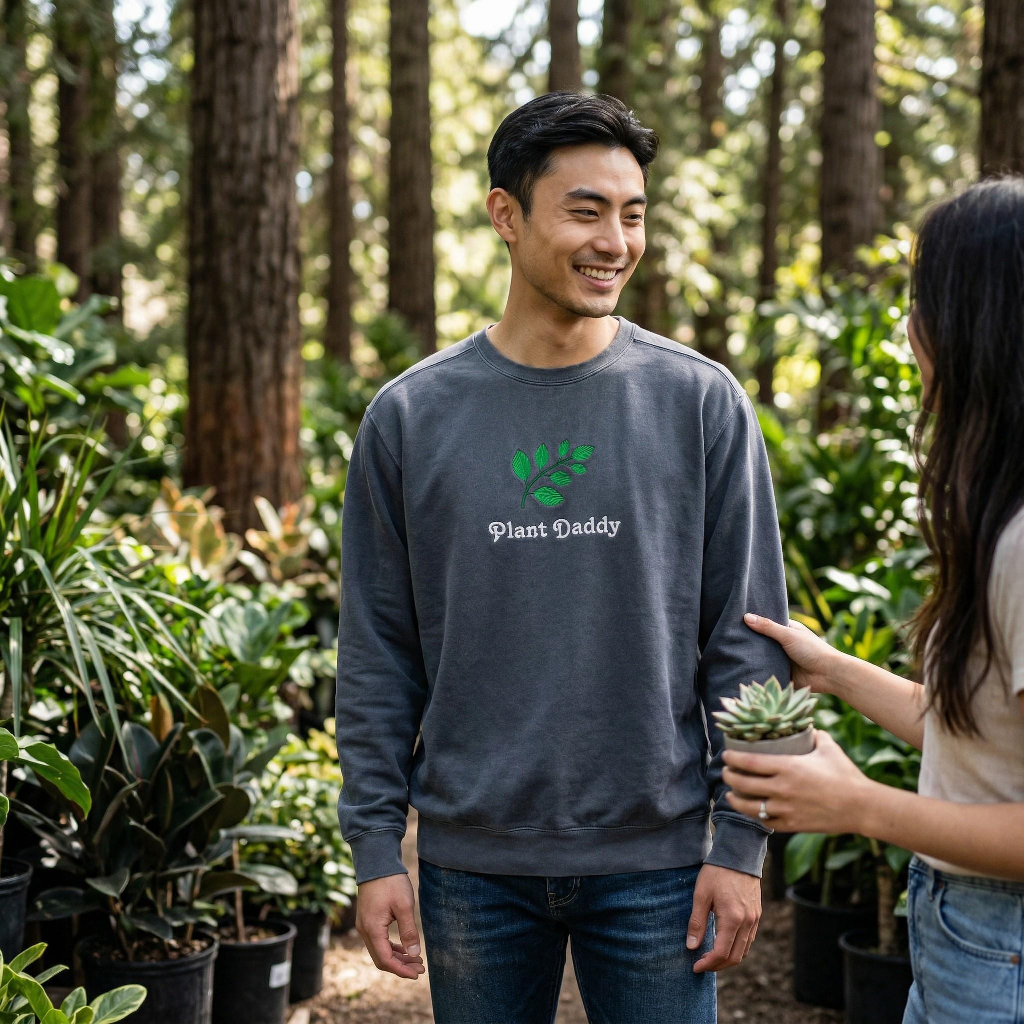 Man wearing a 'Plant Daddy' sweatshirt in a garden setting