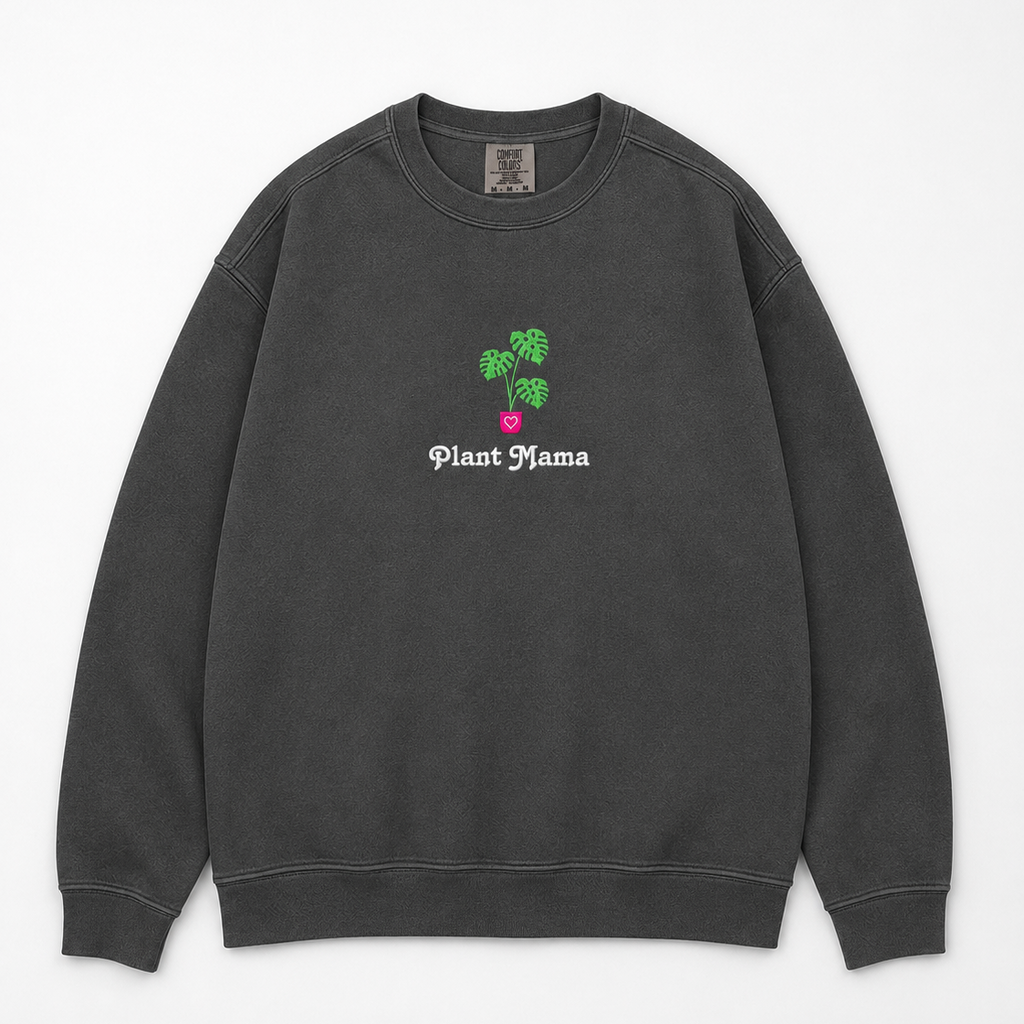 A dark gray crewneck sweatshirt featuring an embroidered monstera plant with in a pink pot and the text 'Plant Mama' in white gothic font.