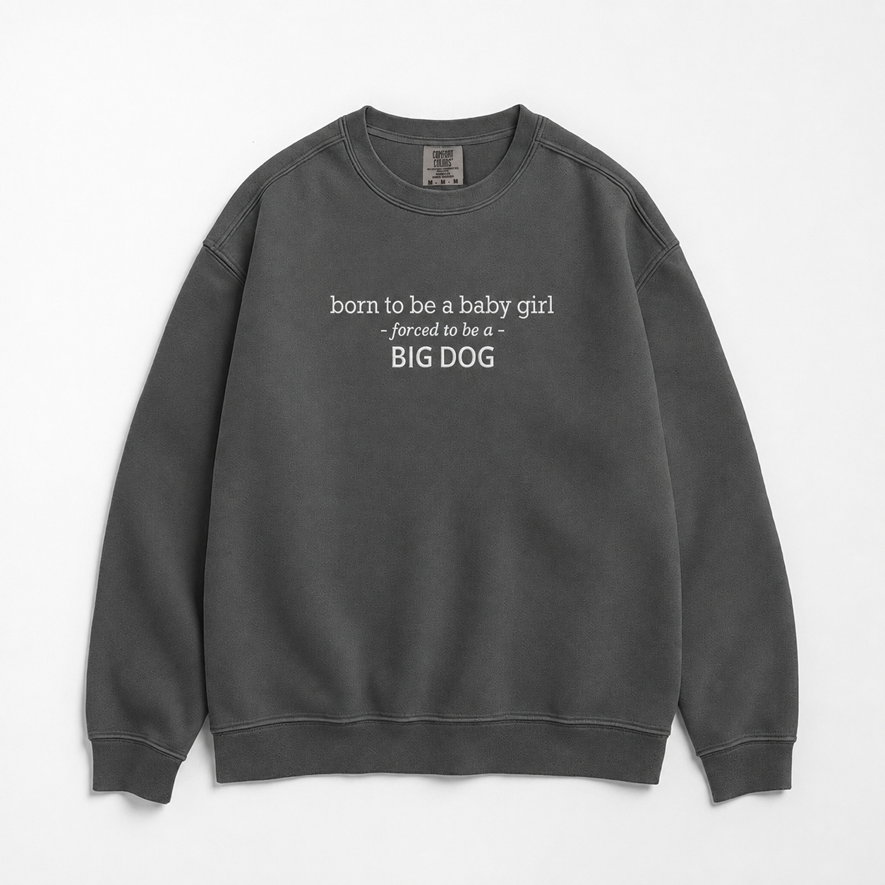 A grey crewneck sweatshirt with white text on the chest reading 'born to be a baby girl -forced to be a - BIG DOG', displayed flat against a white background.
