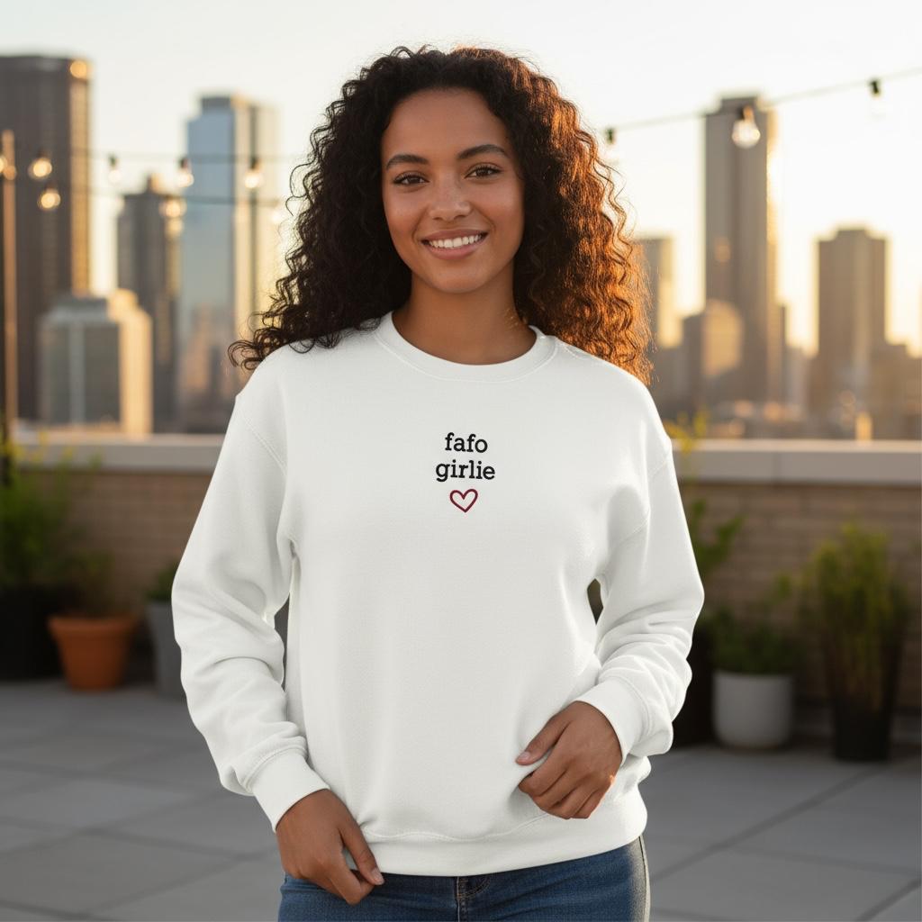 Woman wearing a white sweatshirt with 'fafo girlie' text, standing on a rooftop with city skyline in the background.