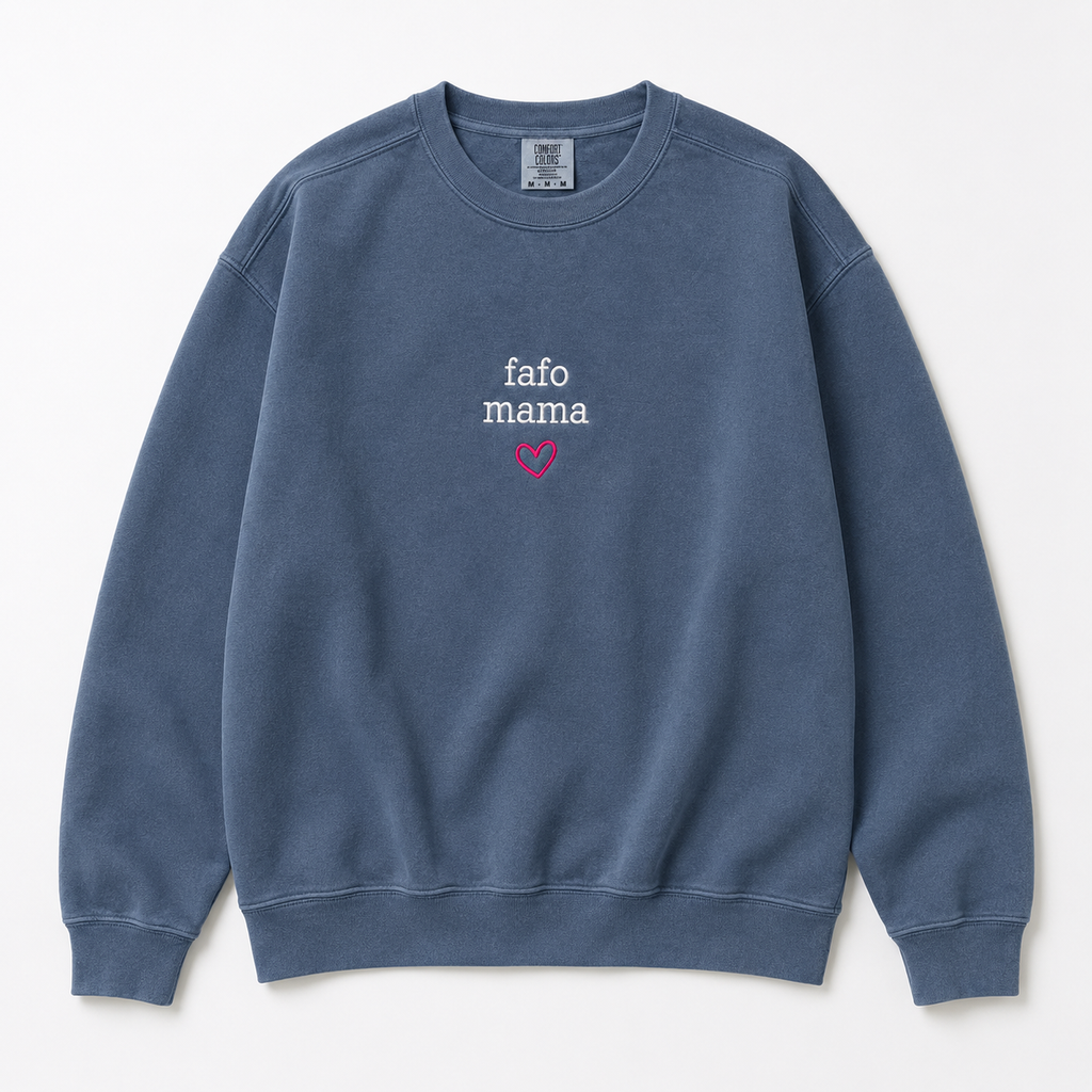 A slate blue crewneck sweatshirt with 'fafo mama' embroidered in white on the chest and a small pink heart graphic below it, displayed flat against a light off-white background.