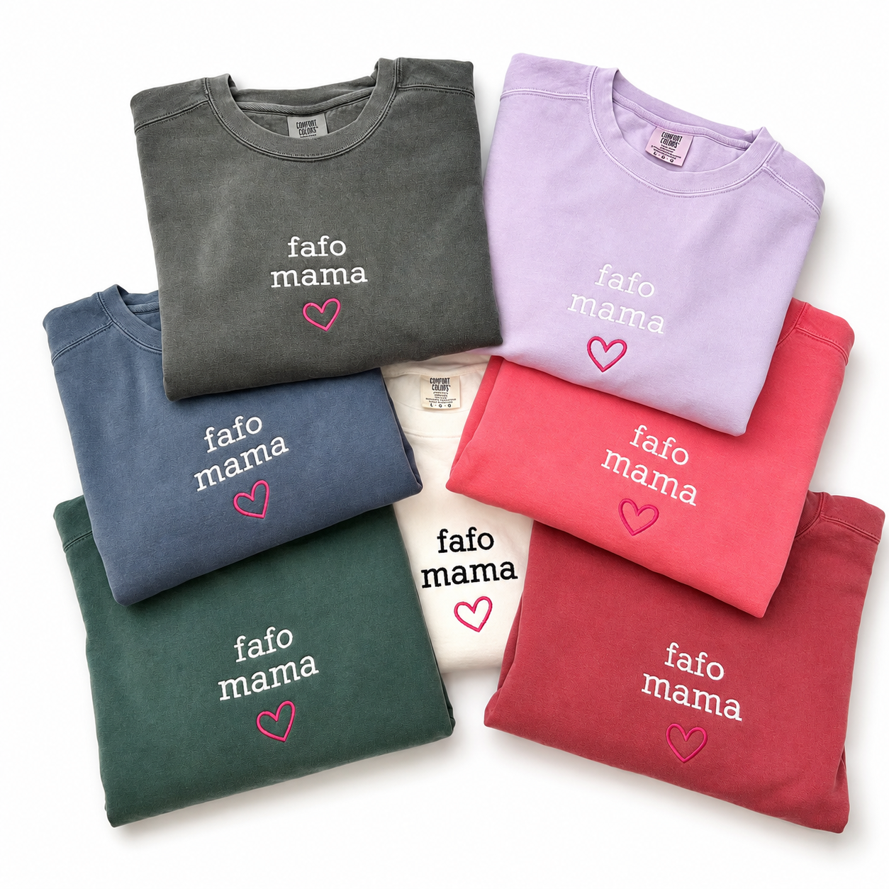 Six folded crewneck sweatshirts in different colors (gray, lavender, blue, green, white, red, pink) arranged in a fan shape on a white background. Each sweatshirt features the text 'fafo mama' in white embroidered font with a small pink heart underneath.