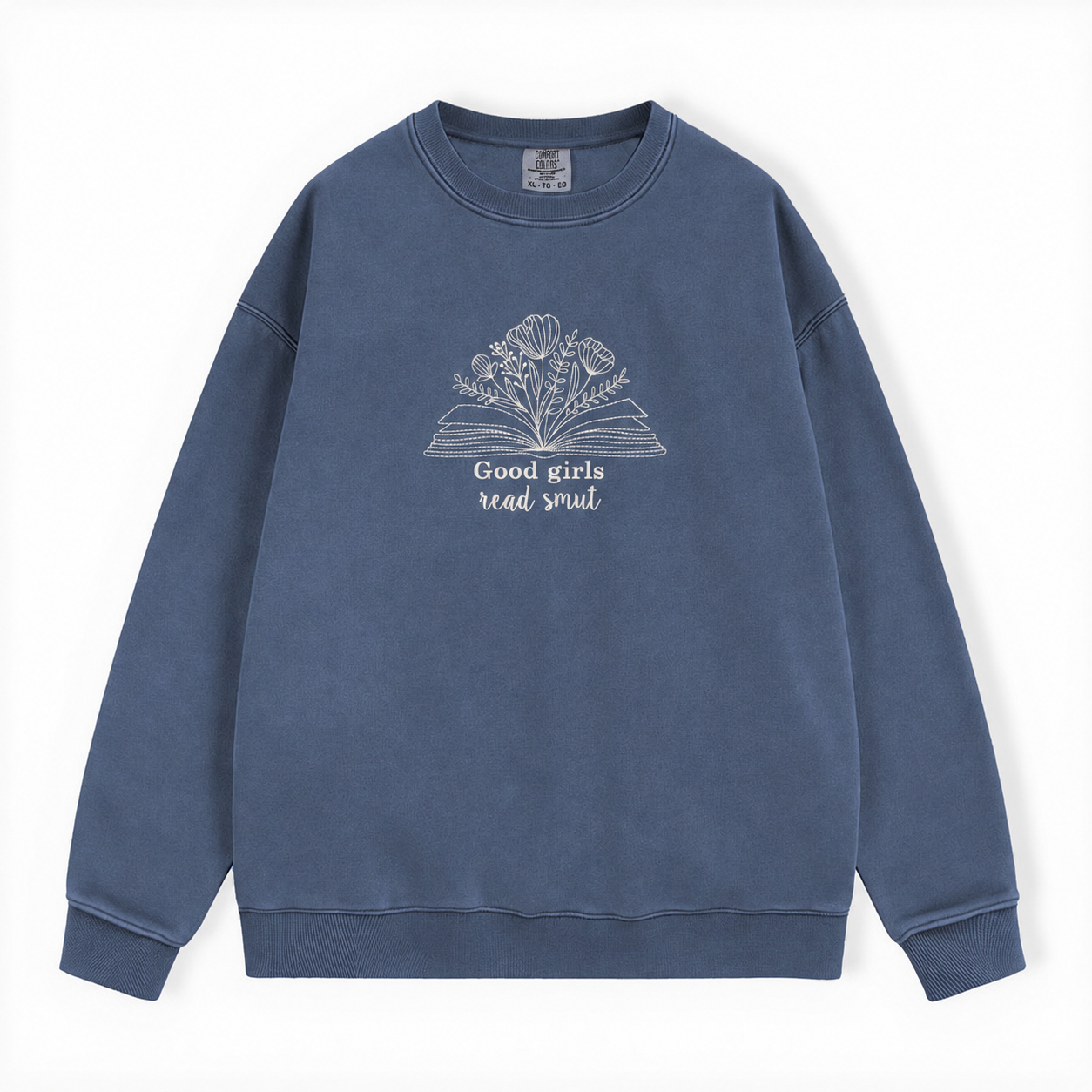 A dusty blue crewneck sweatshirt with a white graphic of an open book and flowers, featuring the text 'Good girls read smut' on the front, laid flat against a white background.