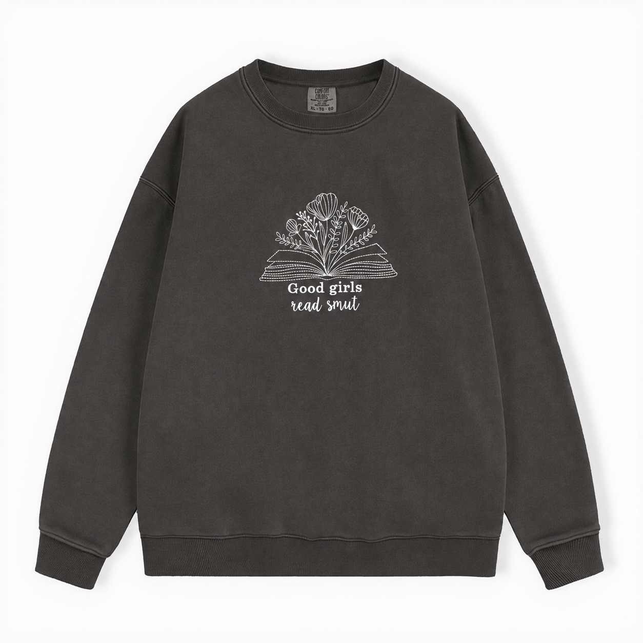 A dark gray washed crewneck sweatshirt featuring a white graphic of an open book with flowers and the text 'Good girls read smut' on the chest, displayed flat against a white background.