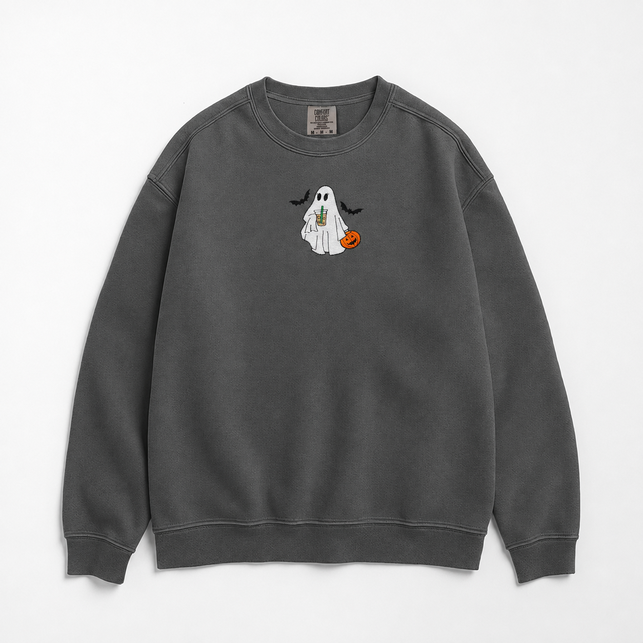 A dark gray crewneck sweatshirt featuring a small Halloween graphic of a white ghost holding a pumpkin and iced coffee. The ghost is flocked by two bats, and the design is on the center chest, displayed against a clean white background.