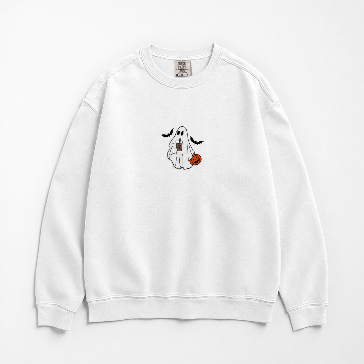 A white crewneck sweatshirt featuring a small cartoon graphic of a ghost holding a pumpkin and iced coffee. The ghost is accompanied by two bats on the center chest, displayed against a clean white background.