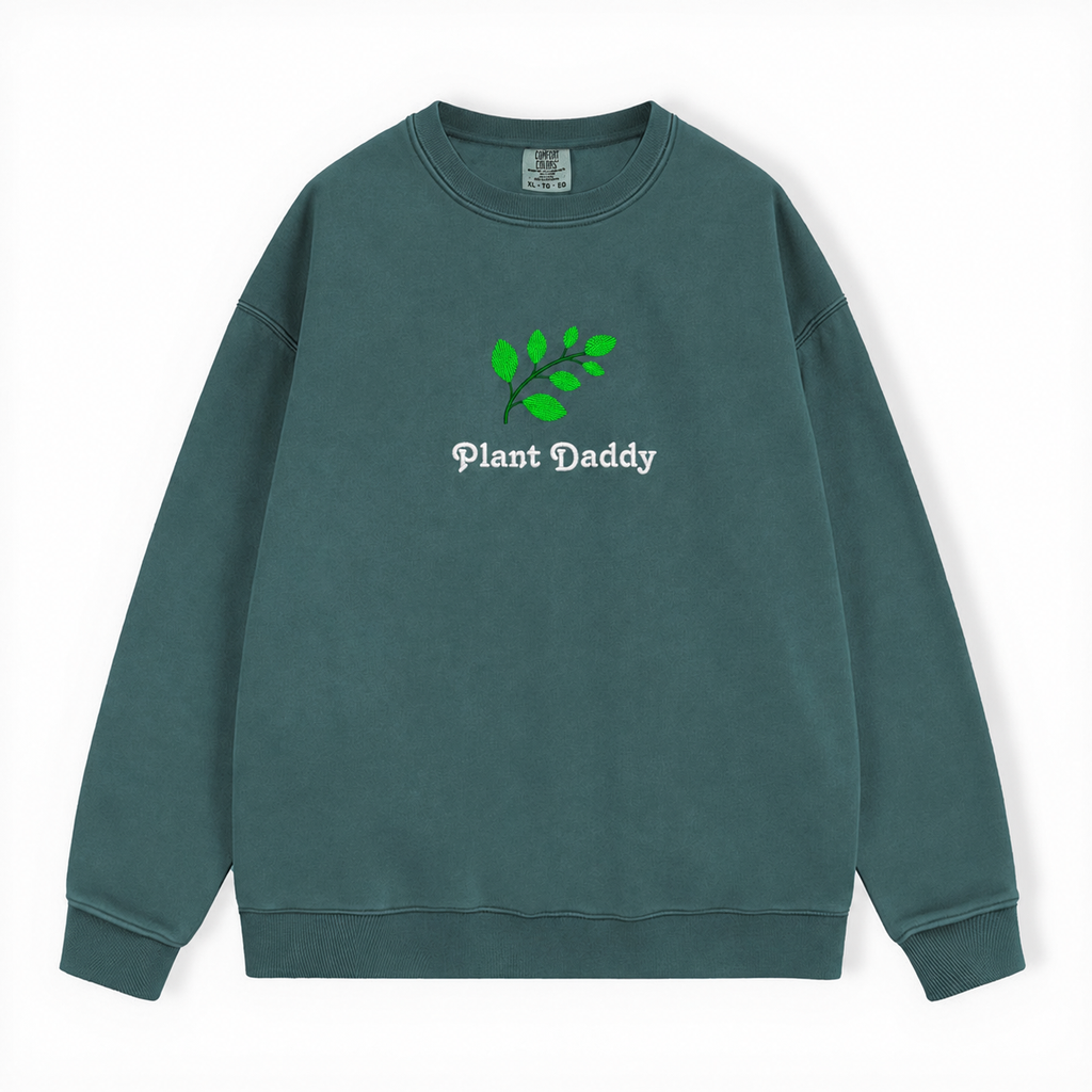 A dark green crewneck sweatshirt featuring an embroidered green leaf and the text 'Plant Daddy' on the chest, displayed flat against a white background.