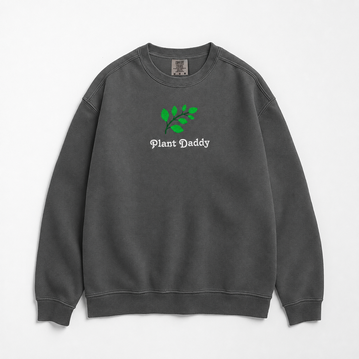 A dark gray crewneck sweatshirt featuring an embroidered green leaf graphic and the text 'Plant Daddy' on the chest, displayed flat against a light gray background.