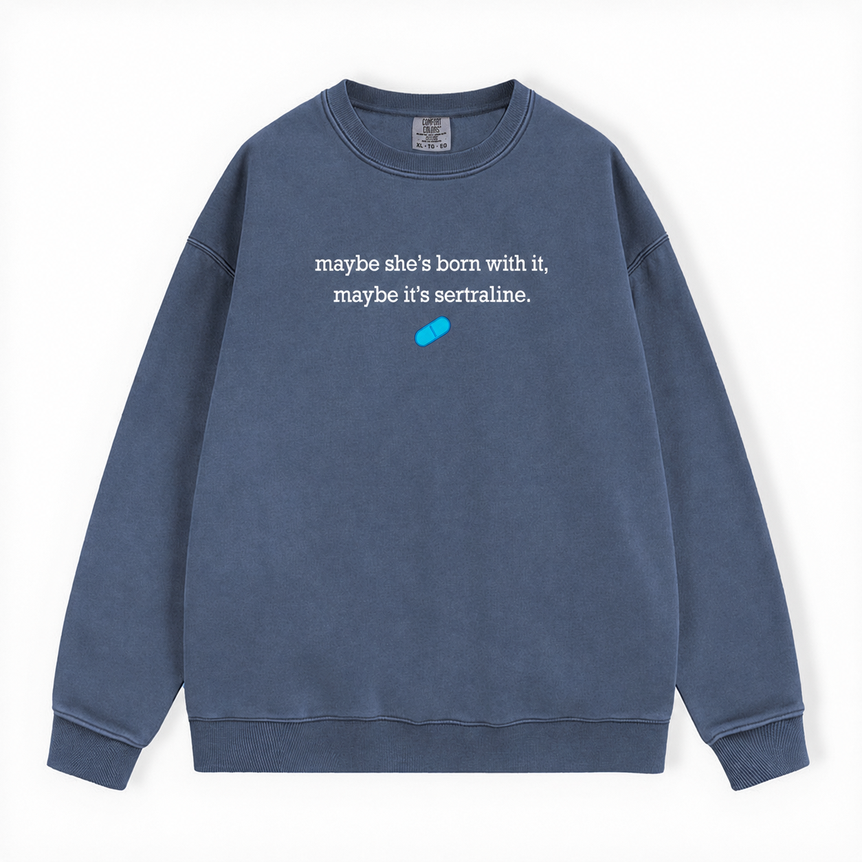 A washed slate blue crewneck sweatshirt featuring the white printed text 'maybe she's born with it, maybe it's sertraline.' and a small bright blue pill graphic on the chest, displayed flat against a white background.