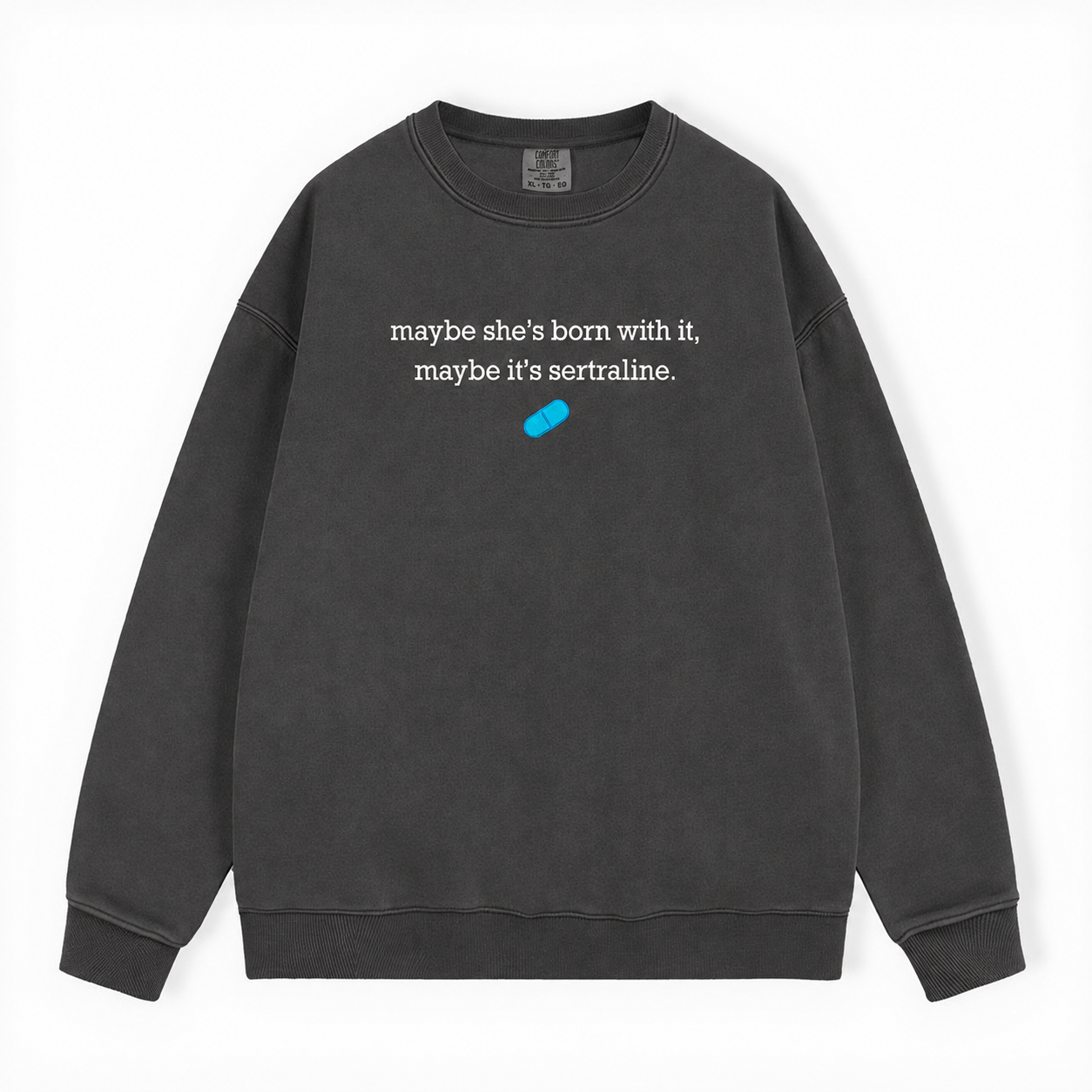 A dark gray washed crewneck sweatshirt featuring the white printed text 'maybe she's born with it, maybe it's sertraline.' and a small blue pill graphic on the chest, displayed on a clean white background.