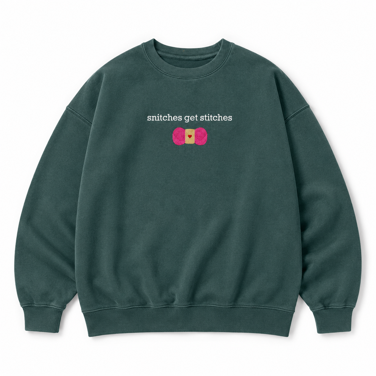 A dark green crewneck sweatshirt featuring a chest embroidered graphic with the text 'snitches get stitches' in white, below a pink skein of yarn.